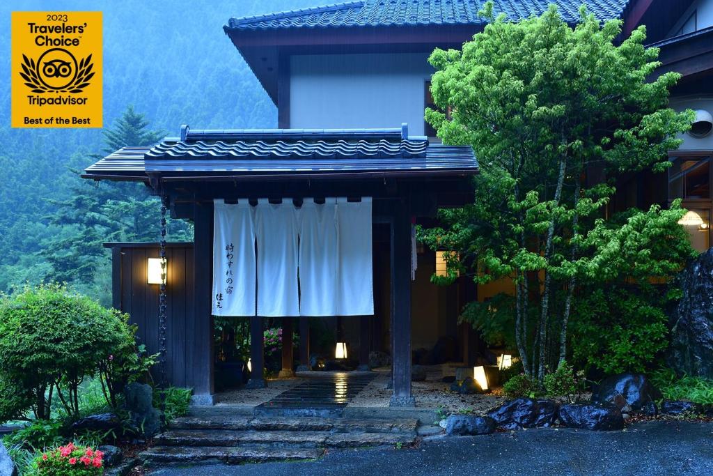 中之条Shima Onsen Yoshimoto的一座带白色窗帘的大门的建筑