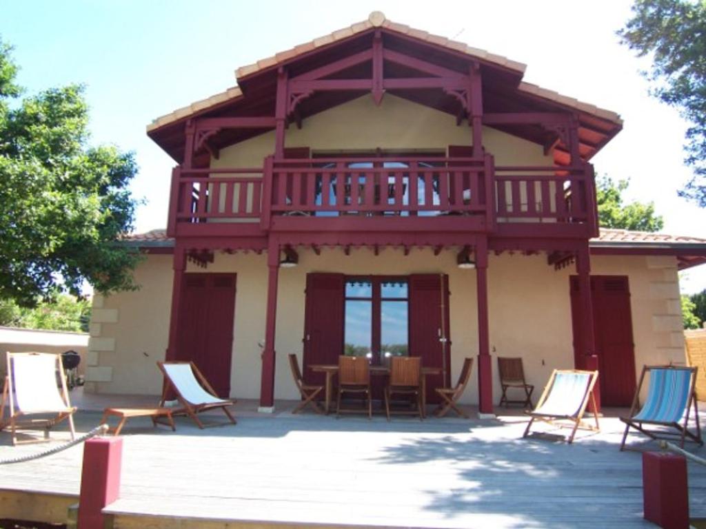 阿卡雄Villa Arcachon, 6 pièces, 10 personnes - FR-1-374-12的房屋前方设有甲板和椅子