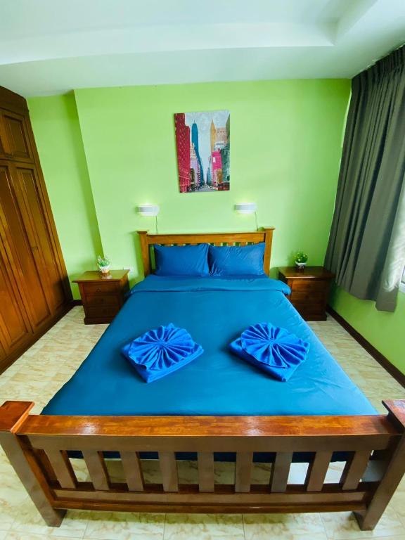 卡塔海滩BT hotel Kata Beach的一间卧室配有蓝色的床和蓝色枕头