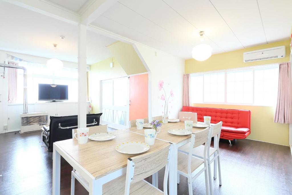 小樽Sungarden - Vacation STAY 95967的一间带桌子和红色沙发的用餐室