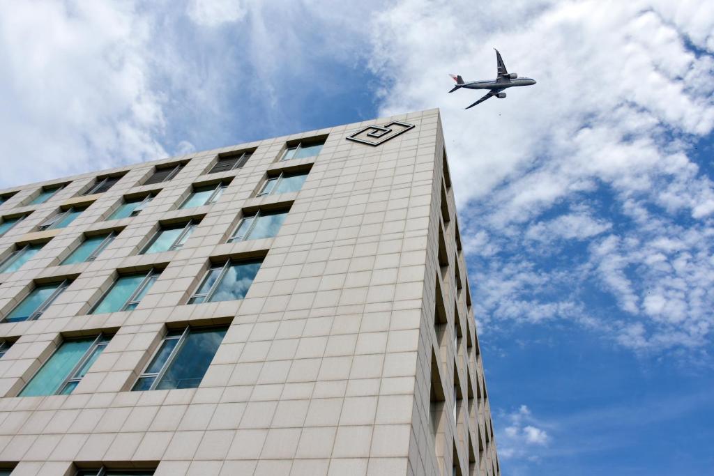 顺义北京首都机场东海康得思酒店 - 朗廷酒店集团全新品牌的飞机飞越高楼