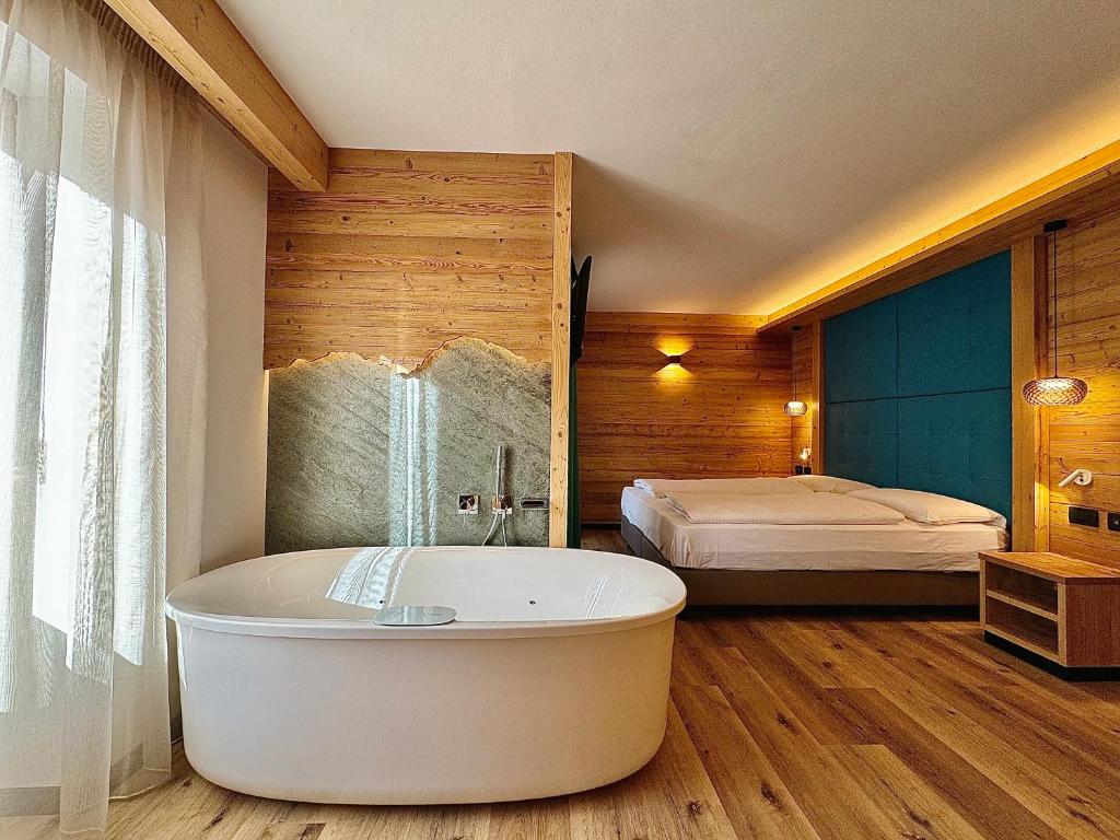 卡纳泽伊Dolomiti Luxury Mountain View的带浴缸和床的浴室