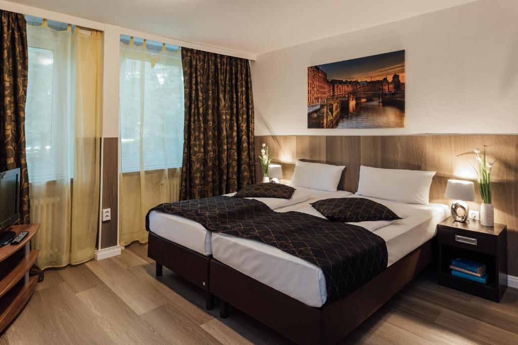 汉堡Hotel Hanseat Hamburg的一间卧室配有一张大床和电视