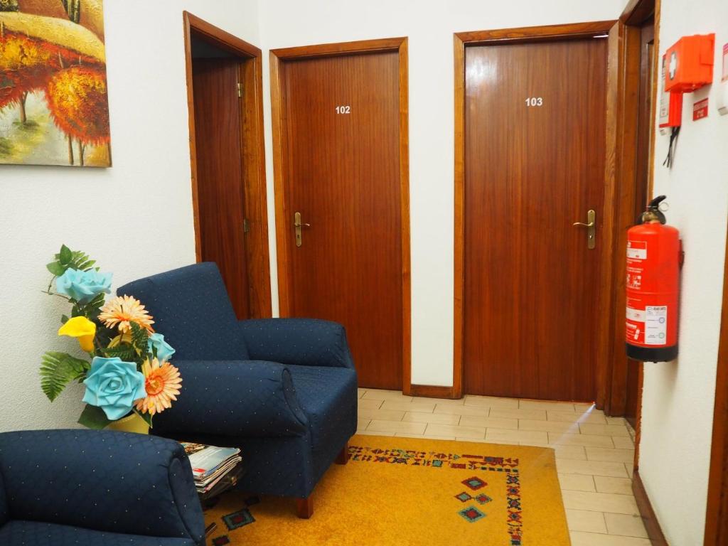 佩德拉斯萨尔加达斯Monte Carlo - Alojamento Local的客厅配有蓝色椅子和灭火器