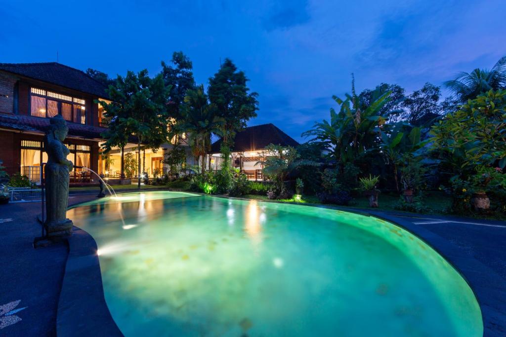 乌布Rahayu Hanoman Ubud的夜晚在房子里的一个空游泳池