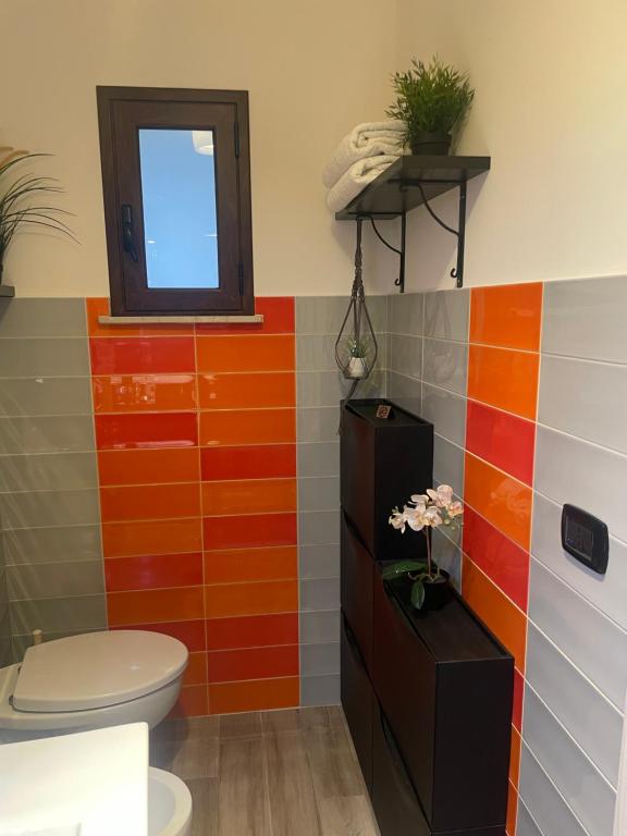 恩纳Archetto-casa vacanze的浴室设有卫生间和彩色瓷砖。