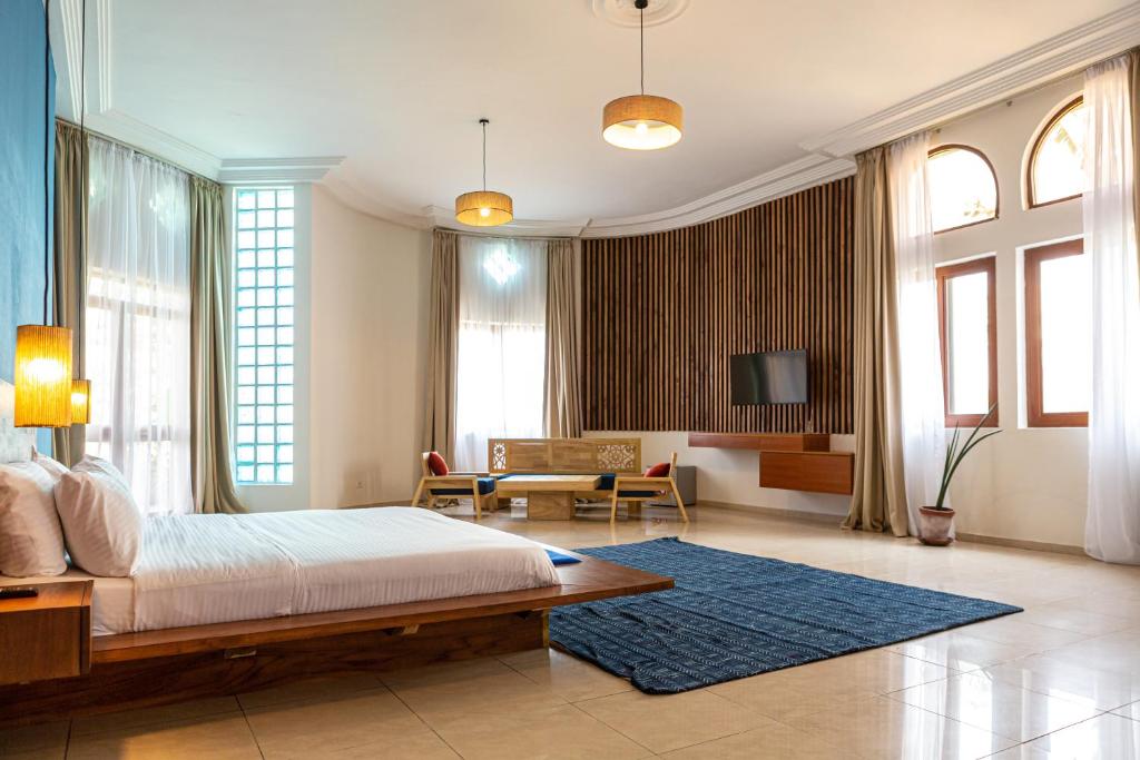 科托努Tamarin Hôtel的一间卧室设有一张床和一间客厅。