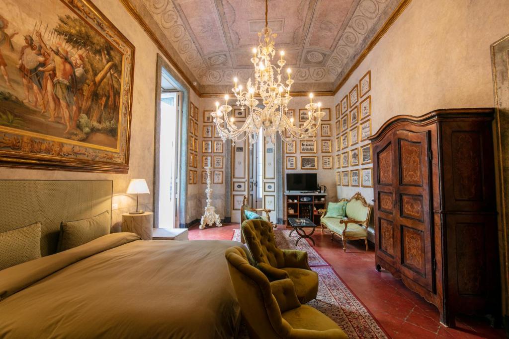 那不勒斯Palazzo Doria Napoli的一间卧室配有一张大床和一个吊灯。