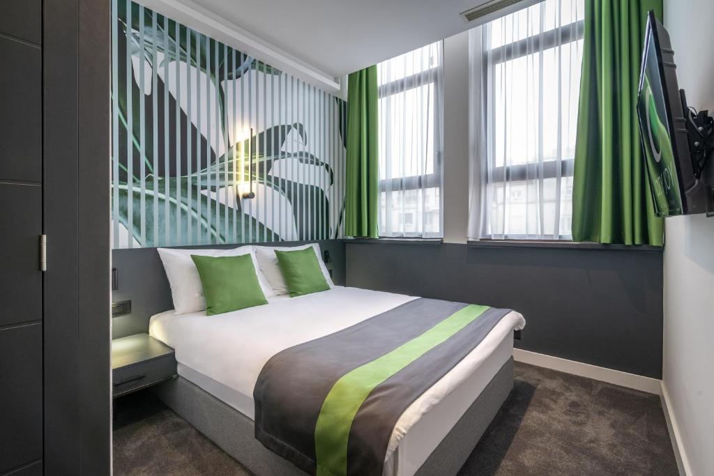 贝尔格莱德City Joy - sports Center Tasmajdan的一间卧室配有一张带绿色窗帘的床