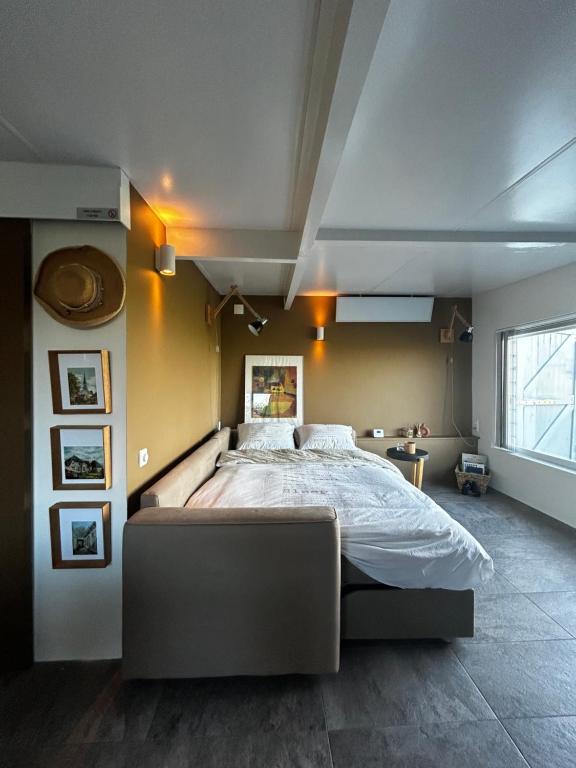 布鲁克因瓦特兰Amazing Guesthouse in Broek in Waterland的一间卧室设有一张大床和一个窗户。