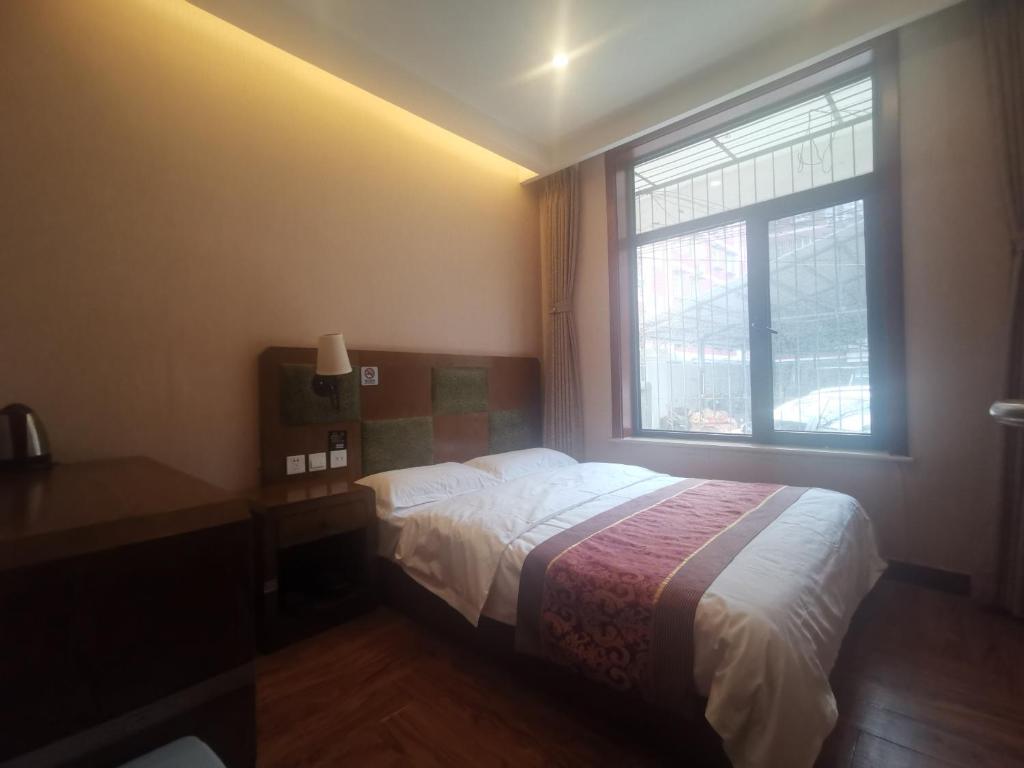 北京北京天坛惠庆园酒店的一间卧室设有一张床和一个窗口