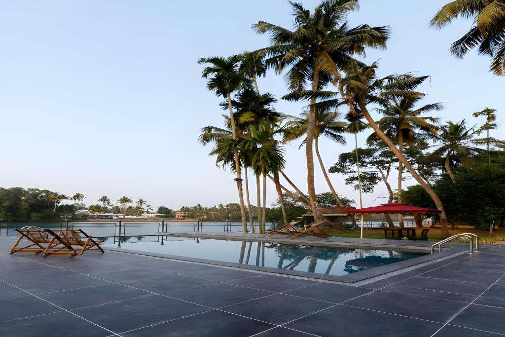 科钦Lhasa Ayurveda and Wellness Resort - A BluSalzz Collection, Kochi, Kerala的棕榈树游泳池及度假村