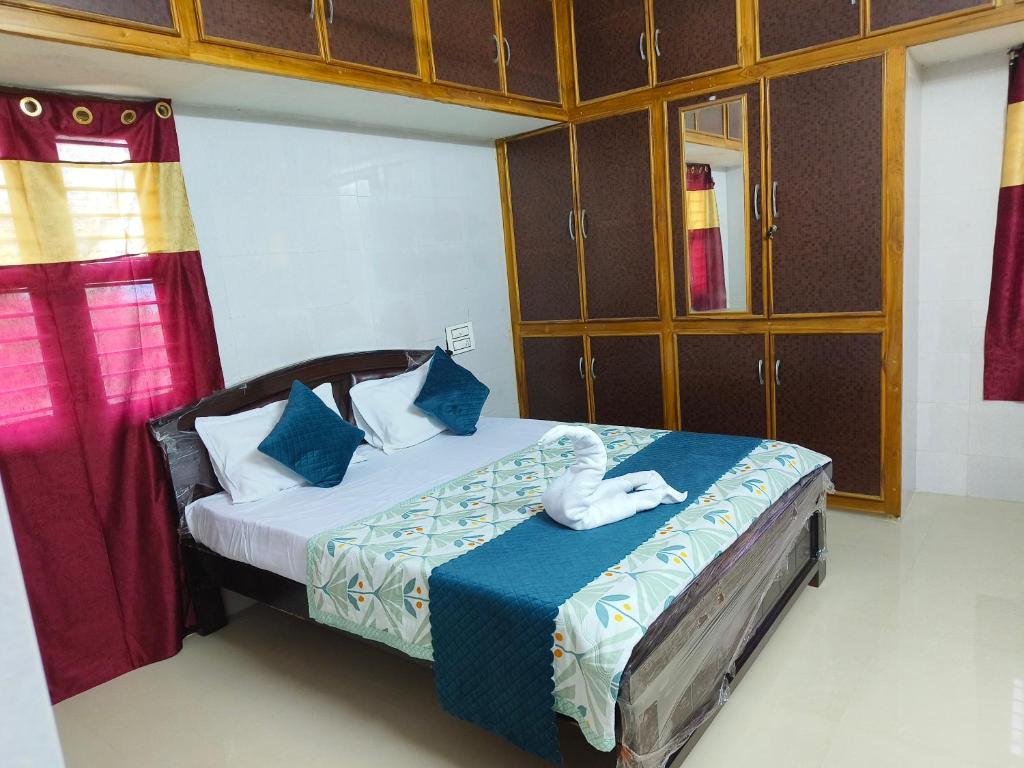蒂鲁帕蒂V1 Stay Home的一间卧室配有一张带蓝色床单和蓝色枕头的床。