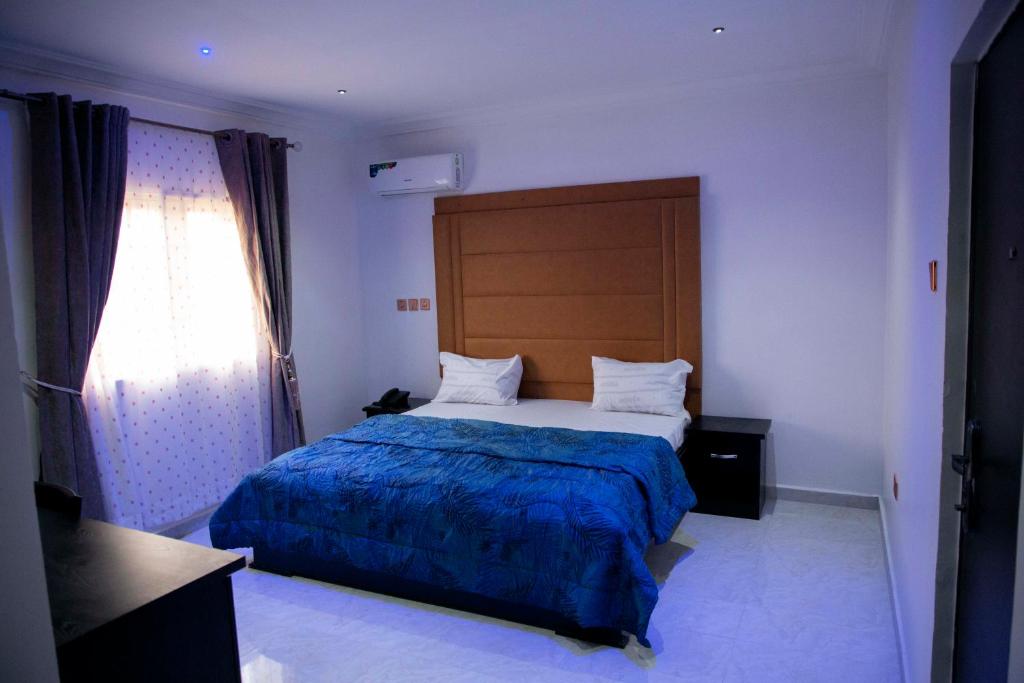 乌约Cogent Apartments Single Rooms的一间卧室配有一张带蓝色毯子的大床