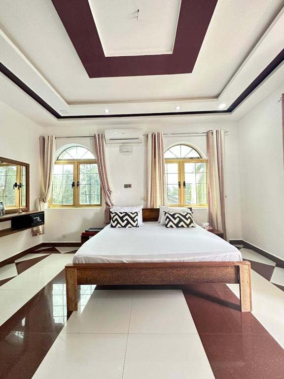 Kiembi SamakiAirport Lux Rooms的一间卧室设有一张大床和格子天花板