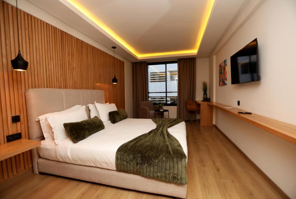 卡萨布兰卡Unico Hotel & Spa Casablanca的一间卧室配有一张床,墙上配有电视