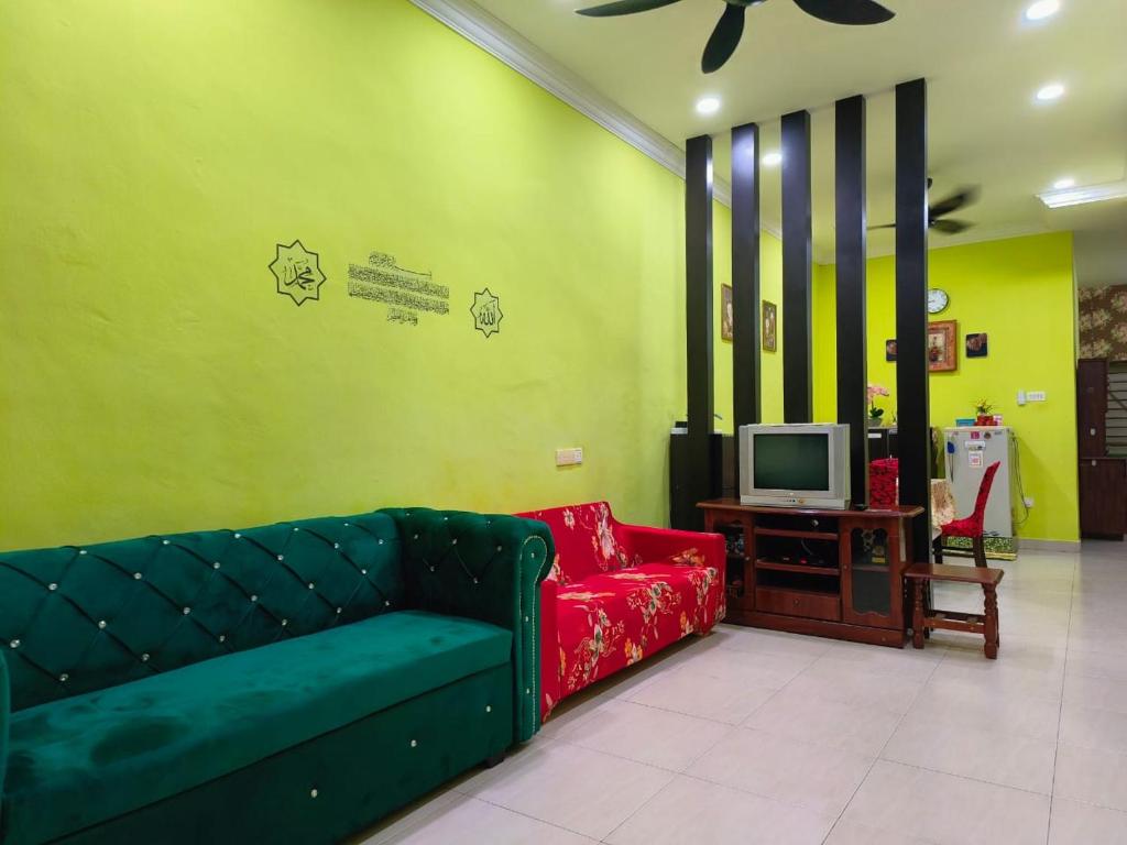 樟仑IRDINA HOMESTAY - Changlun, Kedah的客厅配有绿色沙发和电视