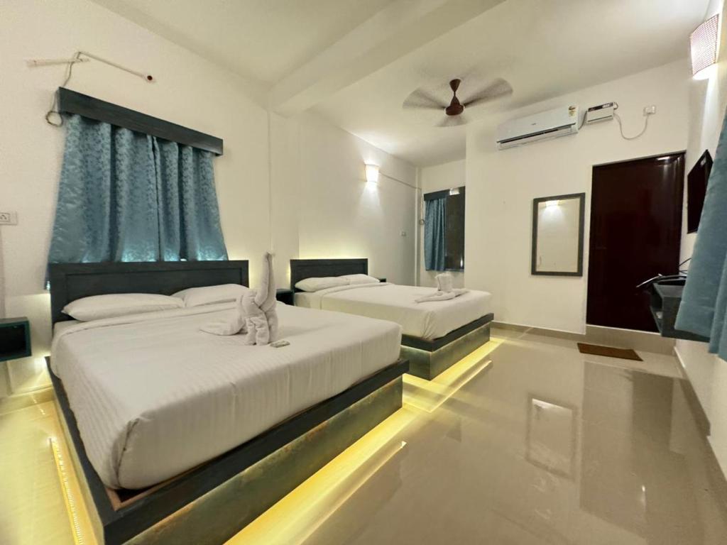 蓬蒂切里La Antilia Luxury的一间卧室配有两张床和吊扇