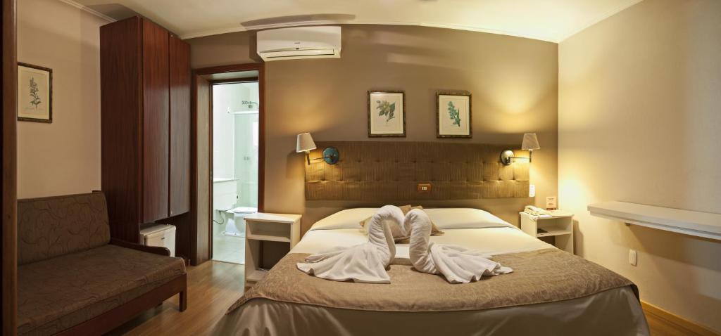 格拉玛多Bellagio Mini Resort - no coração de Gramado的酒店客房,配有带毛巾的床