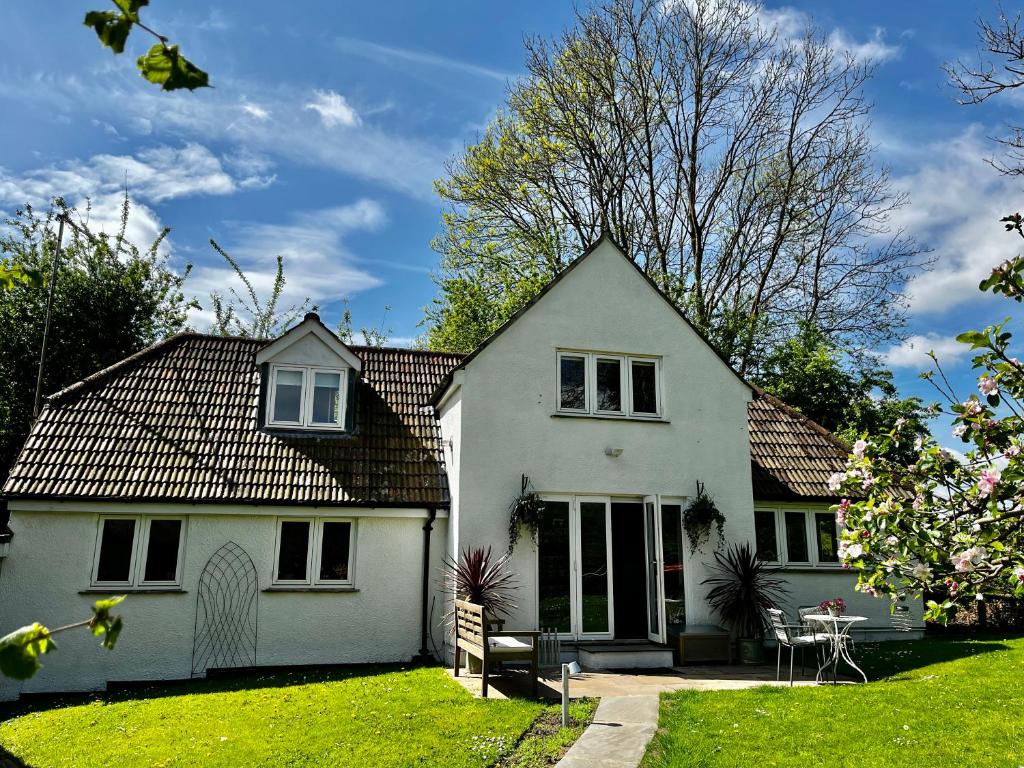 Sutton BengerSpinners House, rural home on edge of Cotswolds的院子里的白色房子,带桌子