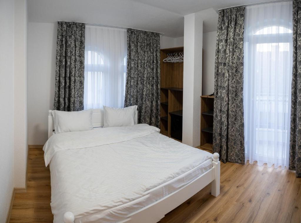 斯特鲁加Hotel Lux的窗户客房内的一张白色床