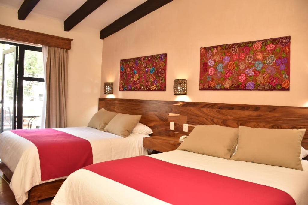圣克里斯托瓦尔-德拉斯卡萨斯德尔山谷酒店大厦的酒店客房,设有两张红色和白色的床