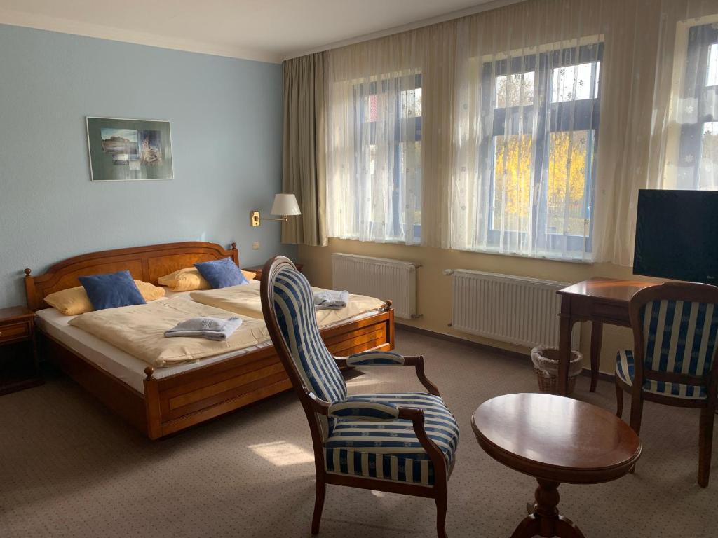 格赖夫斯瓦尔德Ryck-Hotel Garni的一间卧室配有一张床、一把椅子和一张桌子