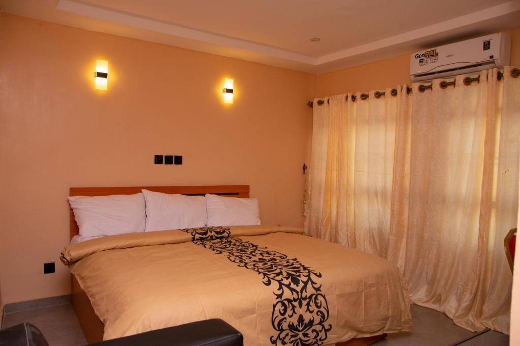 OjoDopad Hills Hotel and Suites的一间卧室配有一张带黑白毯子的床