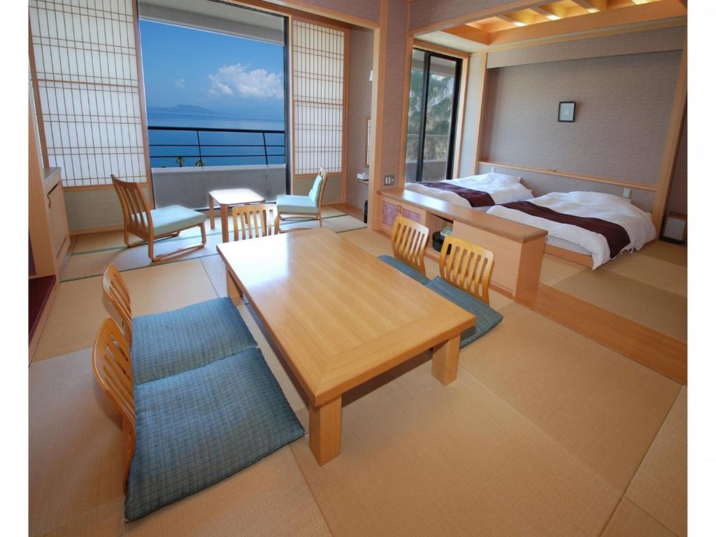 天草市Hotel Alegria Gardens Amakusa - Vacation STAY 40451v的卧室配有一张床和一张桌子及椅子