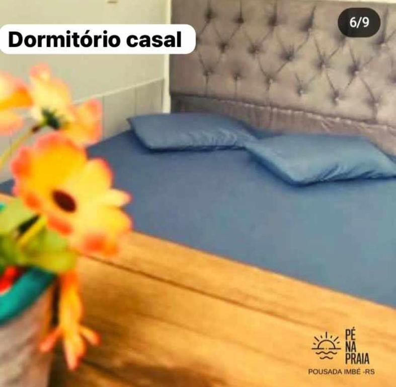 因贝Pousada Pé na Praia的一间卧室配有一张带蓝色床单和蓝色枕头的床。
