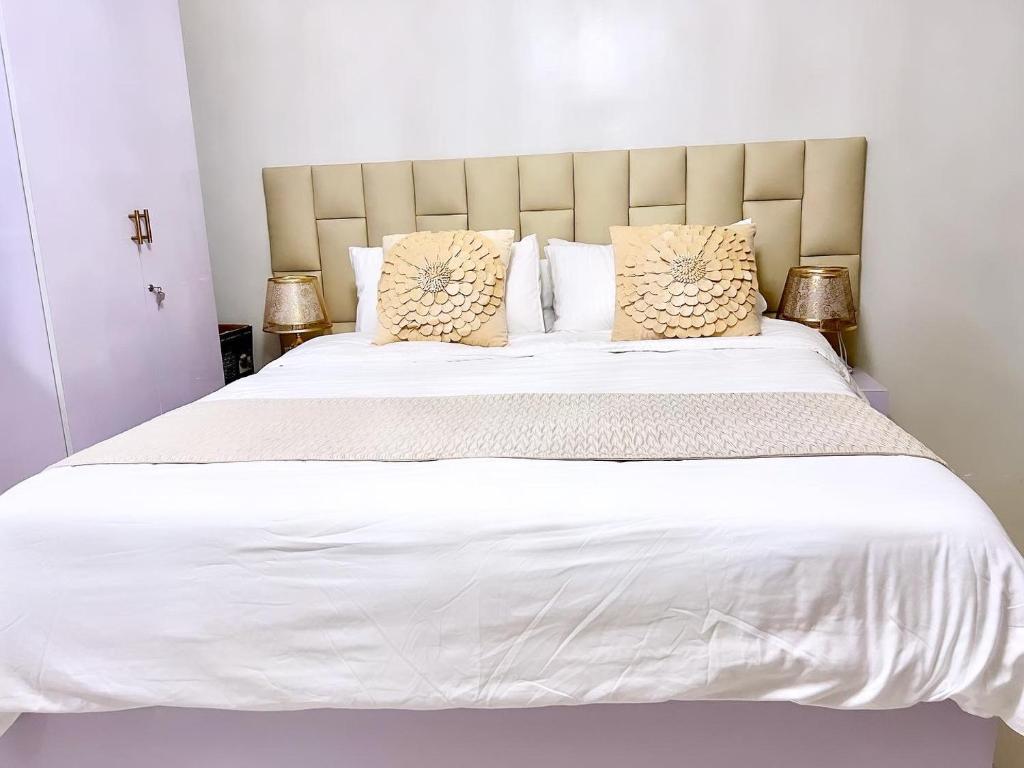 公主港Condo Home in Puerto Princesa near PPS Airport的卧室配有一张带白色床单和枕头的大床。