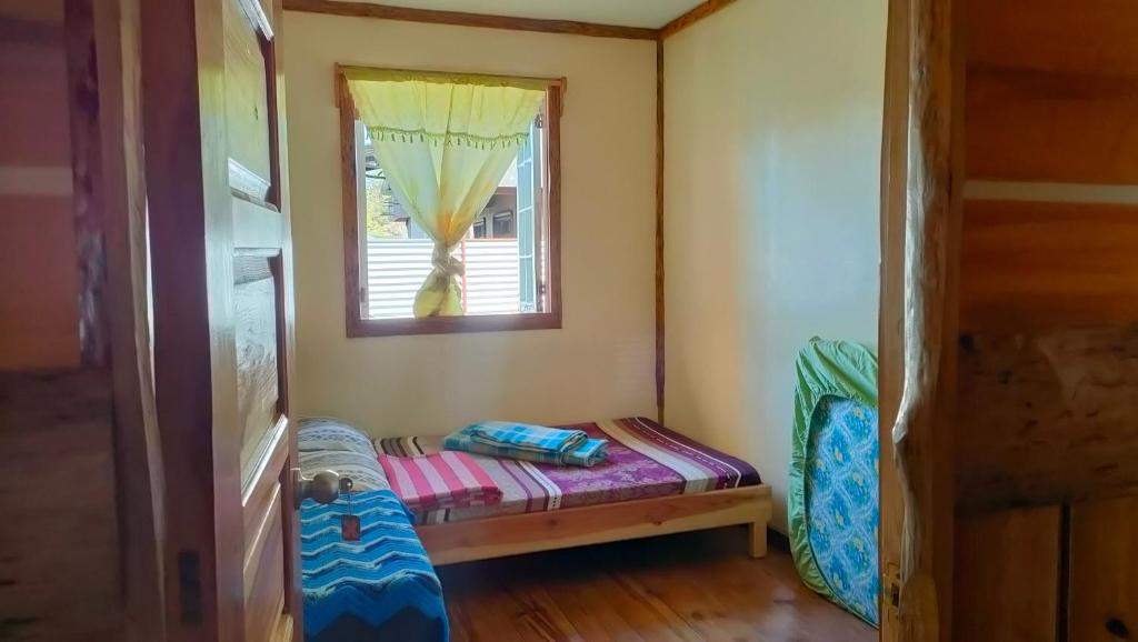 萨加达Acai's Transient House的小房间设有一张小床和一个窗户