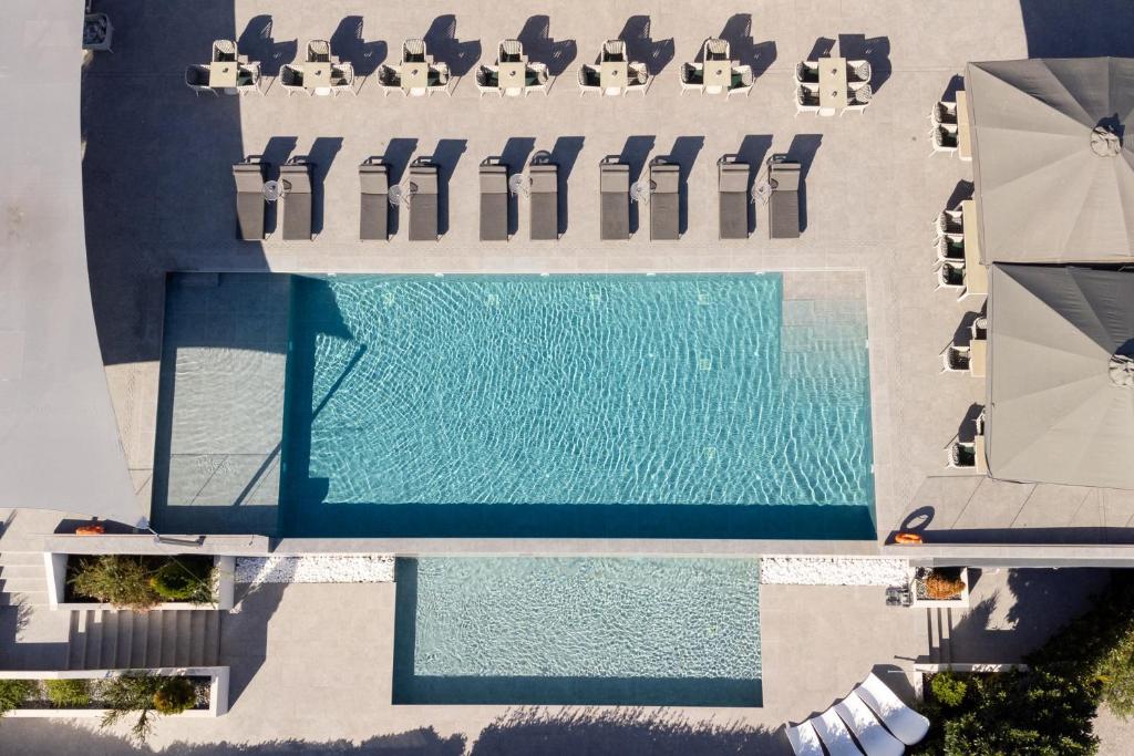 特里卡拉Ananti Resort & Spa的享有带椅子和遮阳伞的游泳池的上方景色