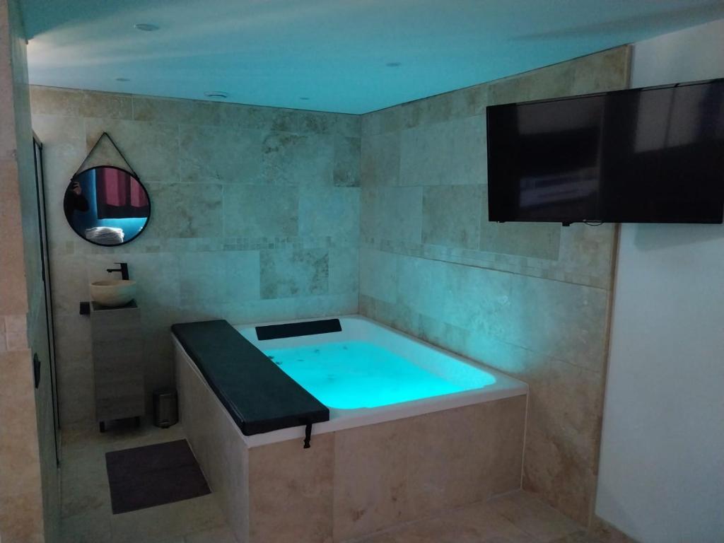 拉西约塔Chalet détente proche plage的浴室设有浴缸、电视和