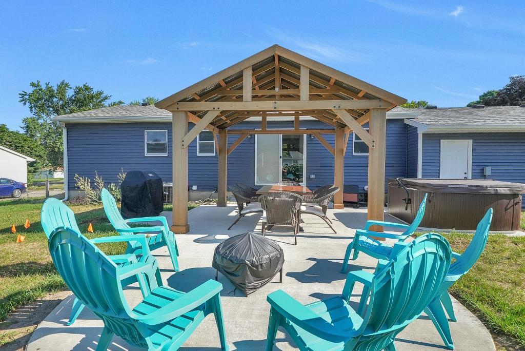 大急流城ELYSIUM - Whole House - 4BR 2BA - Hot Tub - Game Room - Fenced Yard - Pet Friendly的一个带蓝色椅子的庭院和一个凉亭