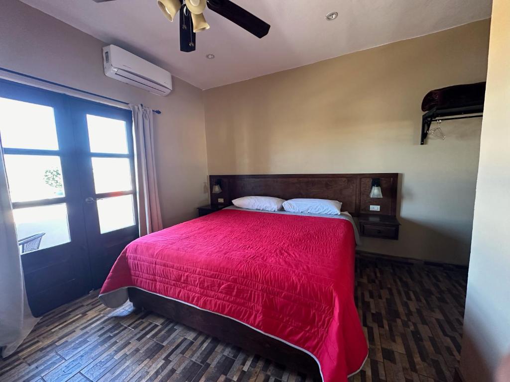 洛雷托Chulavista Loreto的一间卧室设有红色的床和窗户。