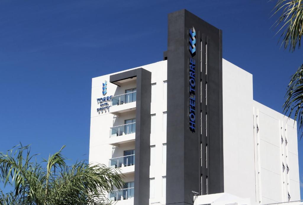 圣克鲁斯伊泽库瓦托雷酒店的白色的建筑,上面有蓝色的标志
