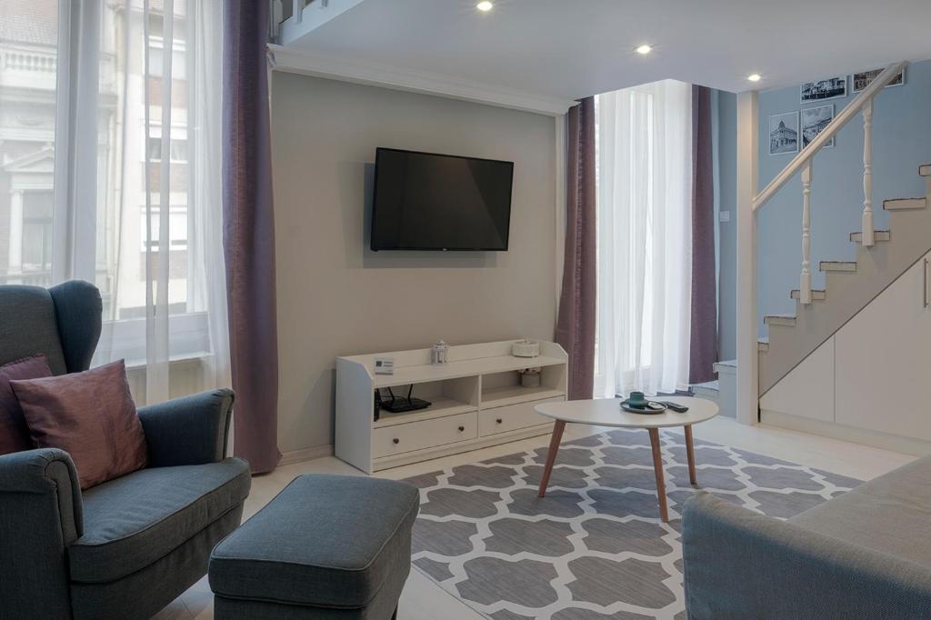 考波什堡S2 Apartman的客厅配有电视、沙发和桌子