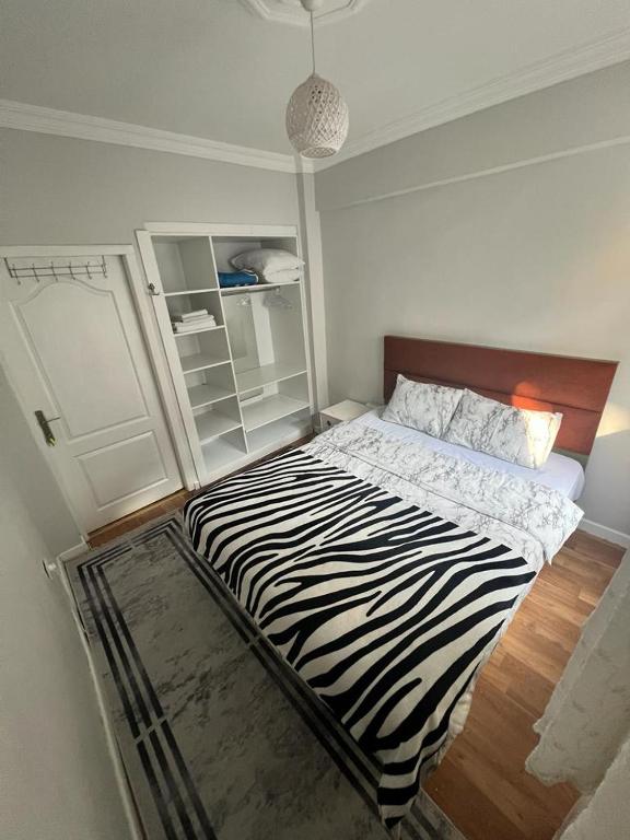 伊斯坦布尔Kadıköy Holiday Home的白色客房内的斑马印花床