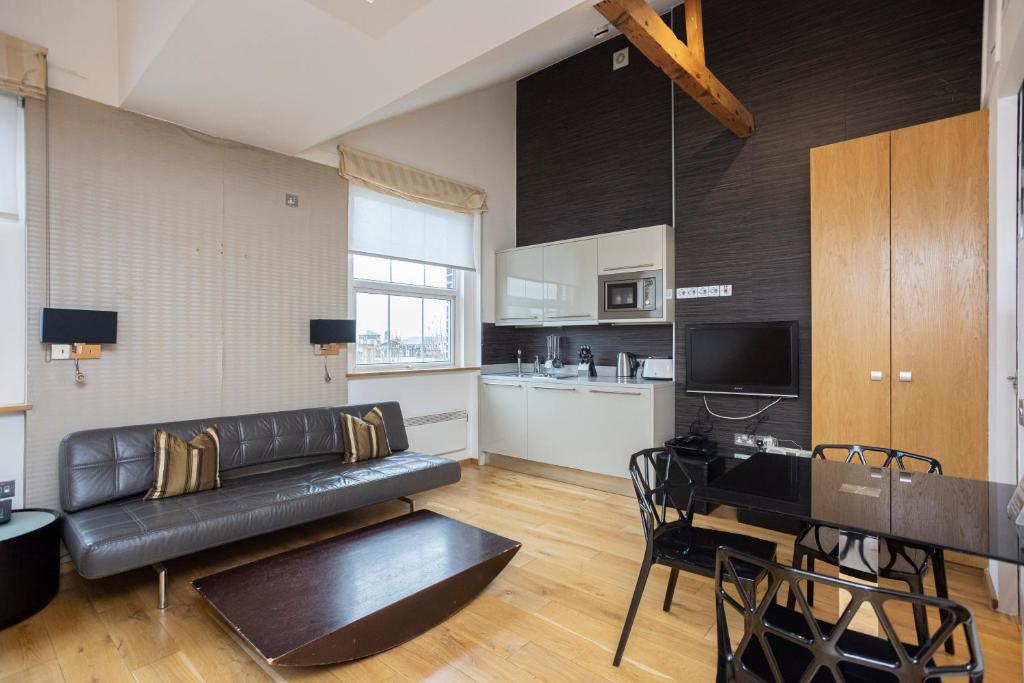 伦敦太空公寓的客厅配有黑色真皮沙发和桌子