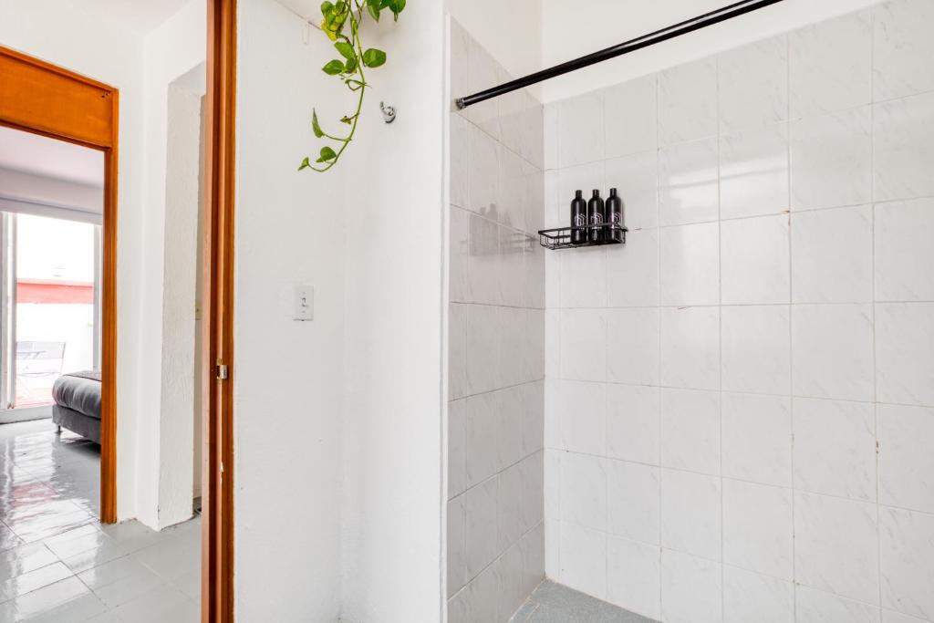 墨西哥城Casa Lumo in Roma Norte by Tasman的浴室设有白色瓷砖淋浴。