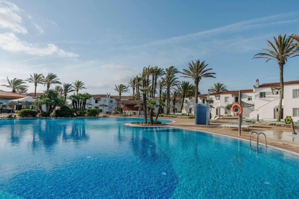 萨尔加AluaSun Mediterráneo的一座棕榈树和建筑的大型游泳池
