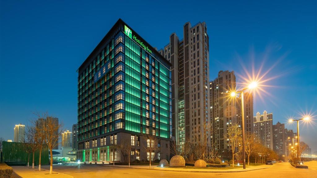 太原太原阳光假日酒店的城市中一座高大的绿色建筑