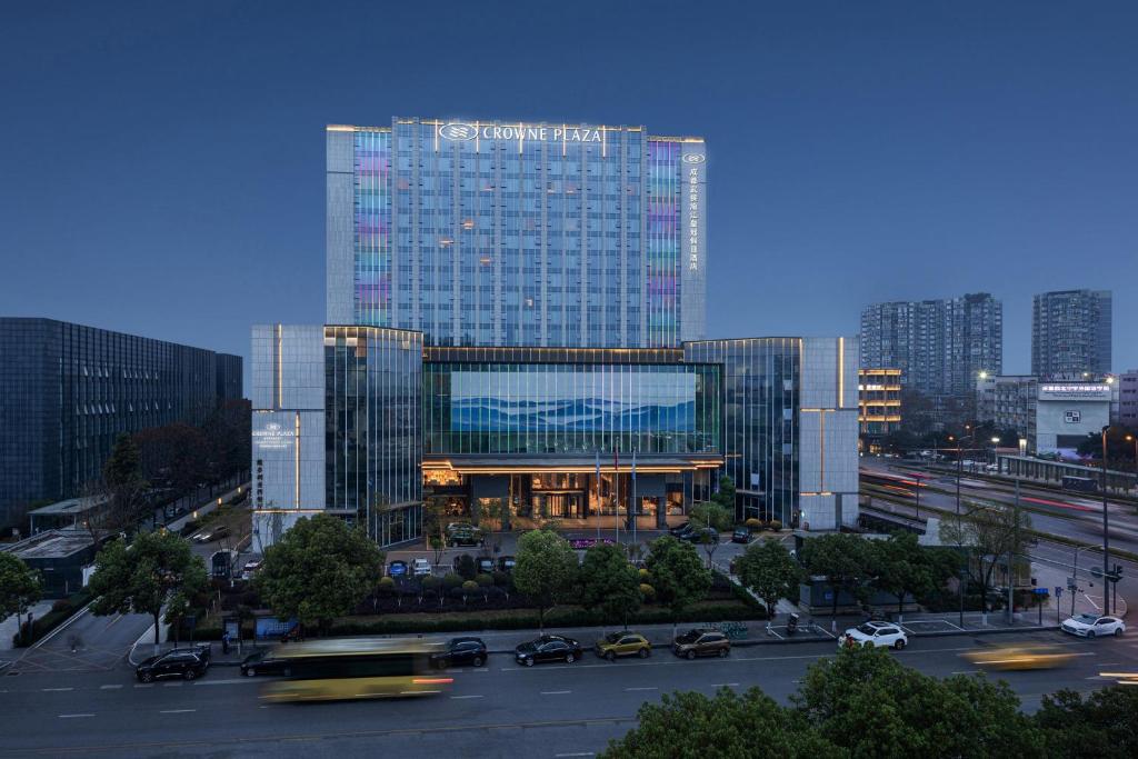 成都成都武侯渝江皇冠假日酒店的一座大型玻璃建筑,在城市里装有汽车
