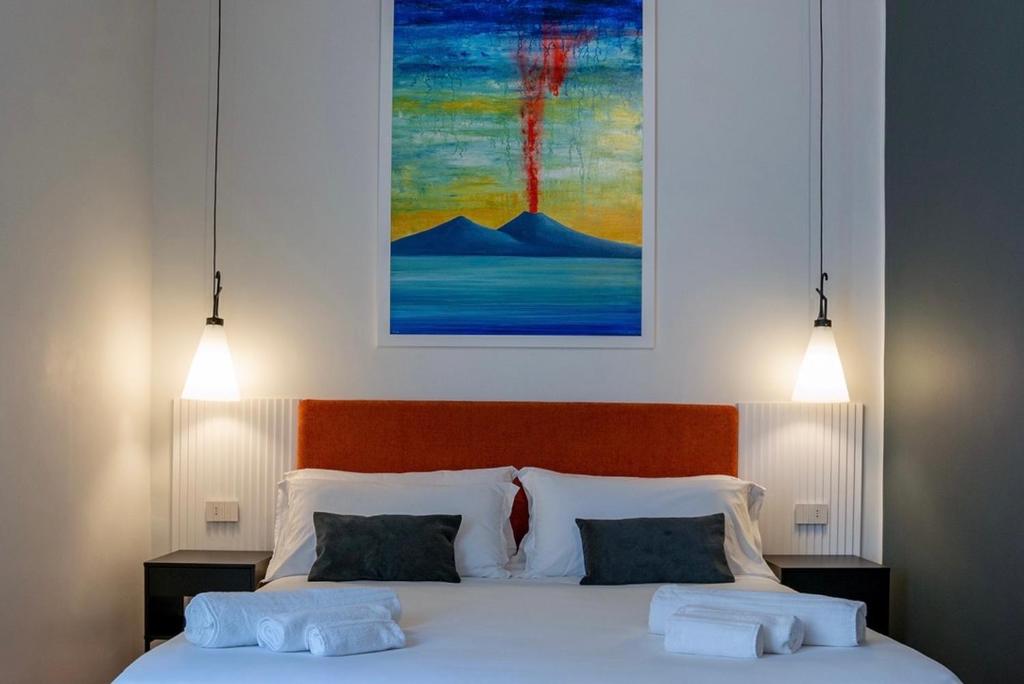 那不勒斯Rolando Domus的一间卧室配有带两个枕头的床和一幅画