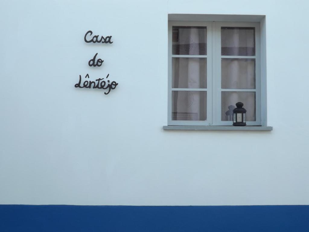 São Pedro do CorvalCasa do Lêntejo - Casas de Taipa的白色建筑上的窗口,上面有读书课的标牌,上面写着洗衣