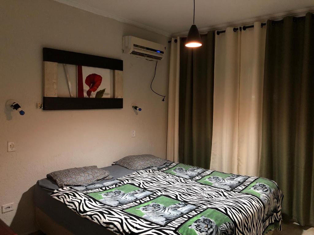 瓜鲁雅Quarto Duplo Costa brava的一间卧室配有一张床,床上铺有斑马毯