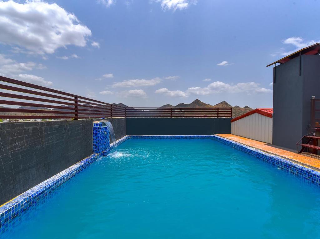 乌代浦Mangal Residency Rooftop Pool的大楼内的一个蓝色海水游泳池