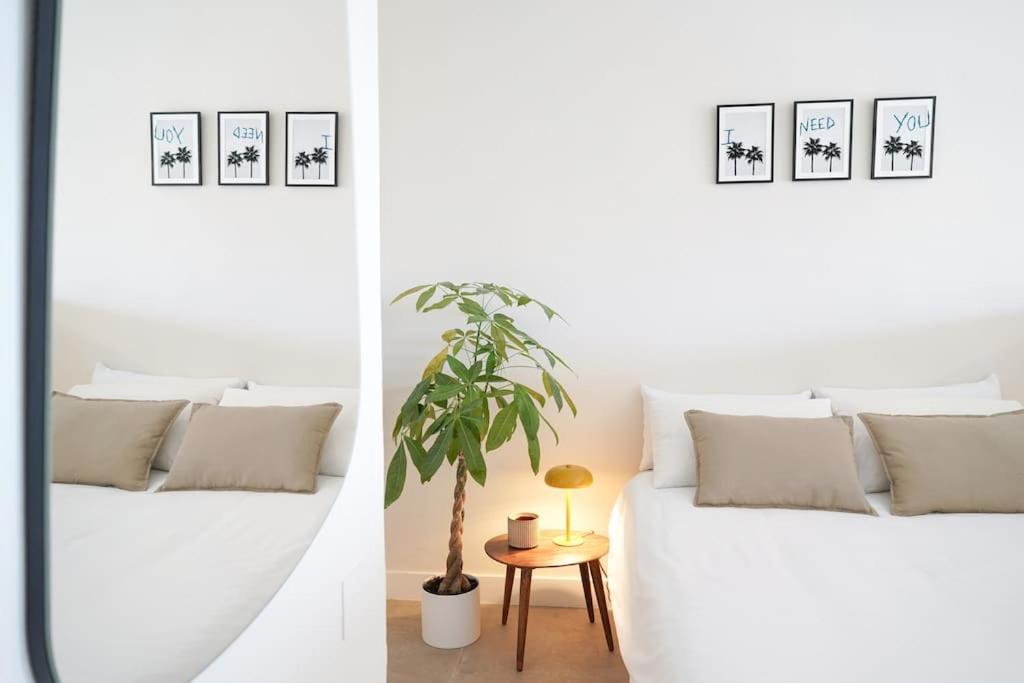 夏约法Studio 10 / Tenerife的白色的卧室,配有白色的沙发和盆栽植物