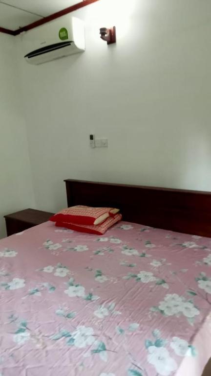 贝鲁沃勒Praveen villa的一张带粉红色床罩的床上花卉床罩